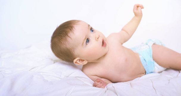Portré egy mosolygó csúszó baba az ágyon a szobájában - Fotó, kép