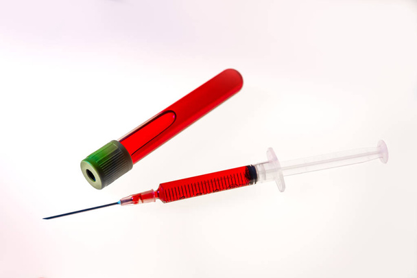 Syringe and tube with blood on white background - Foto, Bild