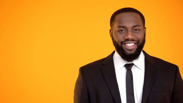 Charming afro-american man in formal suit smiling and looking to camera template - 写真・画像