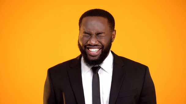 Funny african-american male in formalwear laughing cheerfully, joke and humor - Fotó, kép