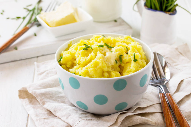Mashed potatoes in bowl with butter and milkon white wooden rust - Photo, Image