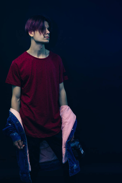 Fiatal férfi rózsaszín és fekete haj piros ing sötét kék háttér. - Fotó, kép