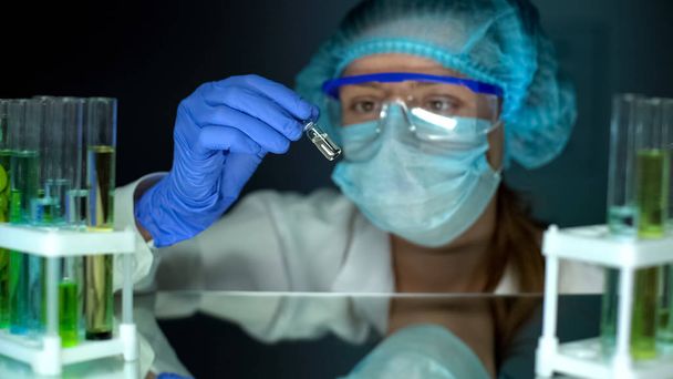 Researcher taking ampule with transparent liquid, antitoxin studies, medication - Foto, Bild