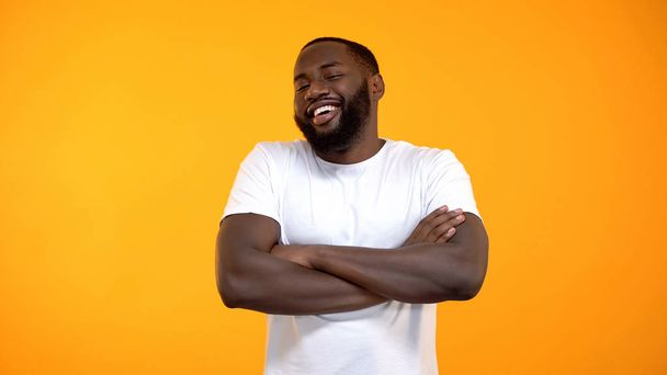 Confident African-American man laughing with hands crossed, funny story - Foto, immagini