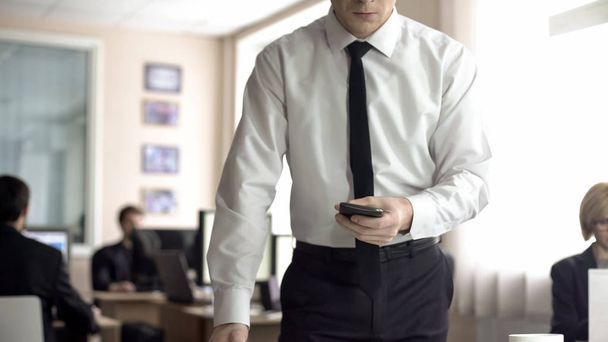 Angry businessman holding cellphone, worrying about problems at work, overwork - Photo, Image