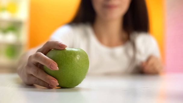 Woman holding green apple, healthy snack, organic fruit, vegetarian lifestyle - Zdjęcie, obraz