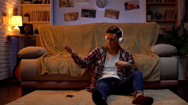 Creative boy in headphones listening to music pretending to play guitar, passion - Фото, зображення
