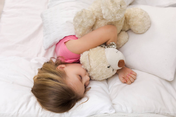 Aranyos kis gyermek lány alszik mackó - Fotó, kép