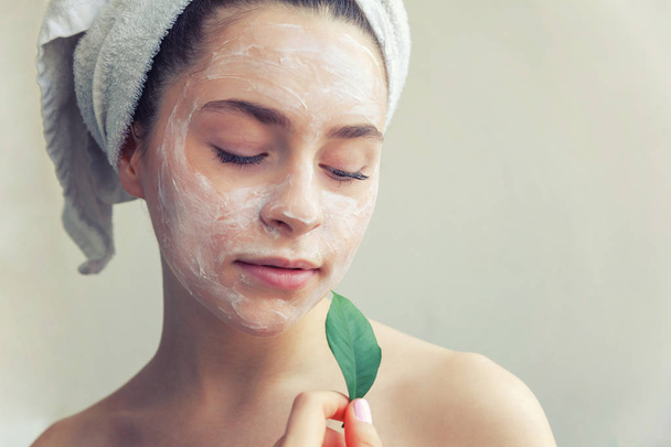 Woman face with green leaf and cream or nourishing mask - Foto, Bild