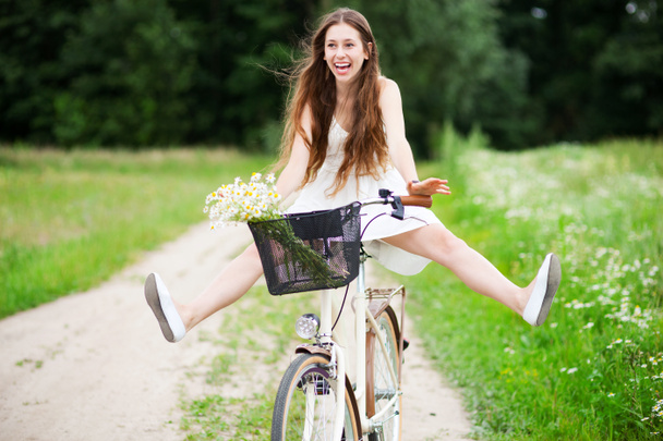 Femme à vélo avec ses jambes dans l'air
 - Photo, image