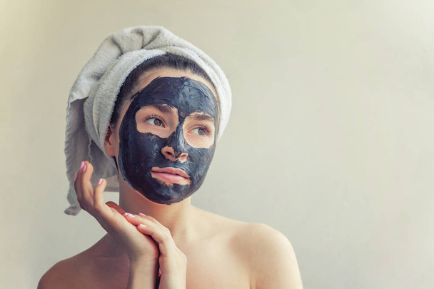 Mujer aplicando máscara negra nutritiva en la cara
 - Foto, Imagen