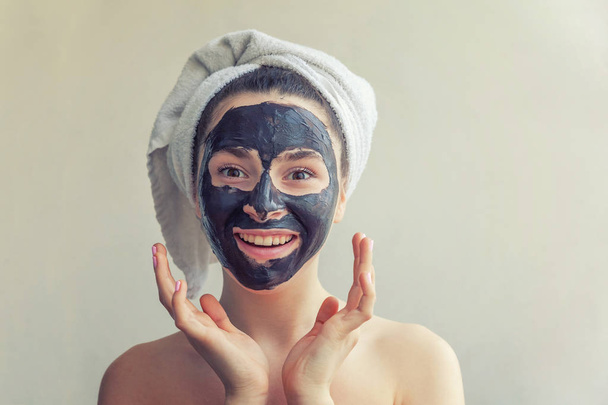 Frau trägt schwarze Pflegemaske auf Gesicht auf - Foto, Bild