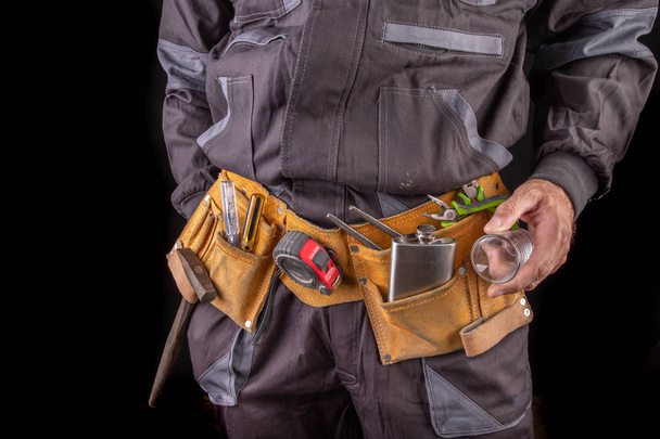 Védőöltözetben dolgozó munkavállaló és vodkát tartalmazó lombik. Részeg PR - Fotó, kép