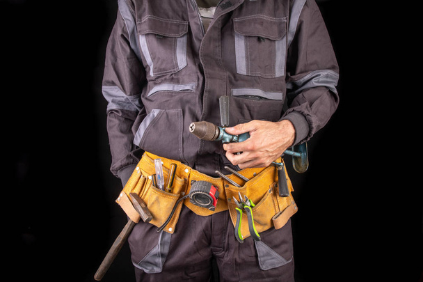 Workman in work clothes and tool belt. Production worker with a  - Φωτογραφία, εικόνα