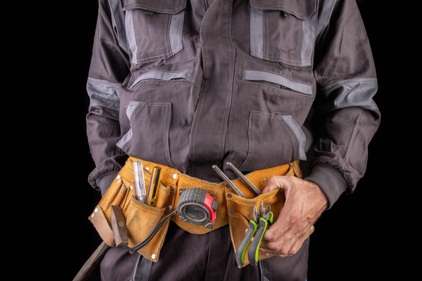 Workman in work clothes and tool belt. Production worker with a  - Photo, Image