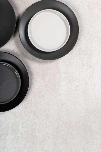 Пустые черные и серые тарелки на сером фоне
 - Фото, изображение