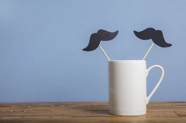 Fathers day coffee mug with a paper mustache against a blue background - Foto, Imagem
