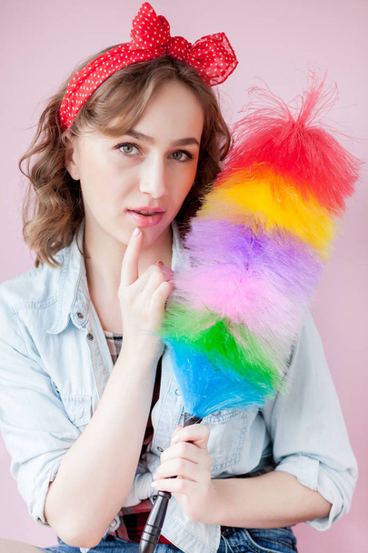 Cleaning pin up woman. Smiling pinup girl holds colorful duster  - 写真・画像