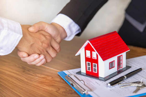 Estate agent shaking hands with customer after contract signatur - 写真・画像