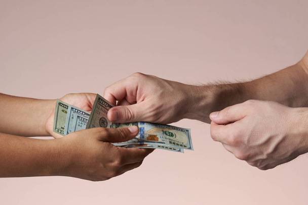 Gros plan des mains donnant de l'argent américain
 - Photo, image
