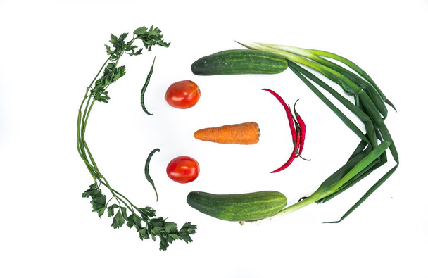 Fresh vegetables in the form of faces with a white background. Chili, eggplant, carrots, tomatoes, cucumber - Foto, Imagen