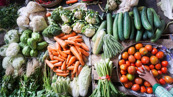 インドネシアの地元市場で販売されている新鮮な野菜 - ニンジン、キュウリ、トウモロコシ、トマト、チリ、マスタードグリーン - 写真・画像