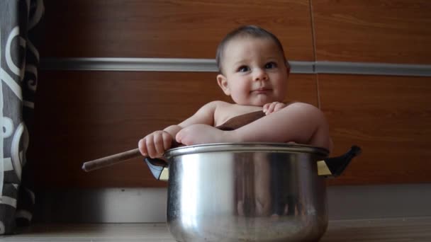 süßer sechs Monate alter Junge spielt mit Kochtopf und Kochlöffel - Filmmaterial, Video