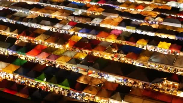 Nachts beleuchtete Marktzelte. Blick von oben auf bunte, hell erleuchtete Zelte des Ratchada rot fai train night market auf der Touristenstraße von Bangkok. Beliebte Attraktion, Streetfood und Shopping - Filmmaterial, Video
