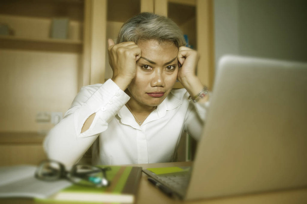atraktivní deprimovaná a smutná zralá asijská podnikatelka pracující v kancelářském psacím stole, která pociťovaná a ohromená úzkostná krize a deprese - Fotografie, Obrázek