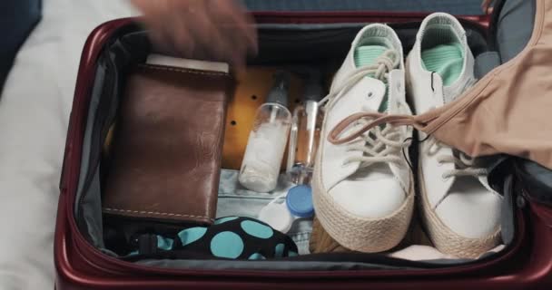 Womans hands packing suitcase for a journey on the bed at home. Travel preparations. - Imágenes, Vídeo