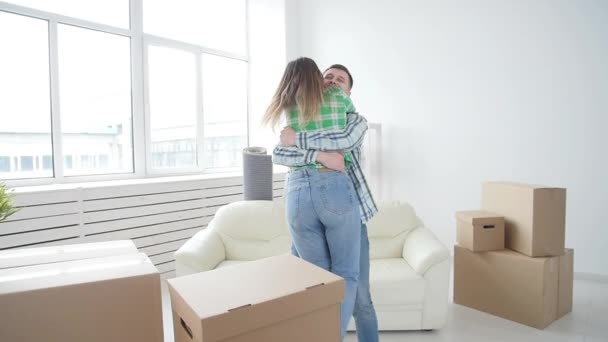 不動産の購入と賃貸の概念。新しい家で抱きしめる幸運なカップル - 映像、動画