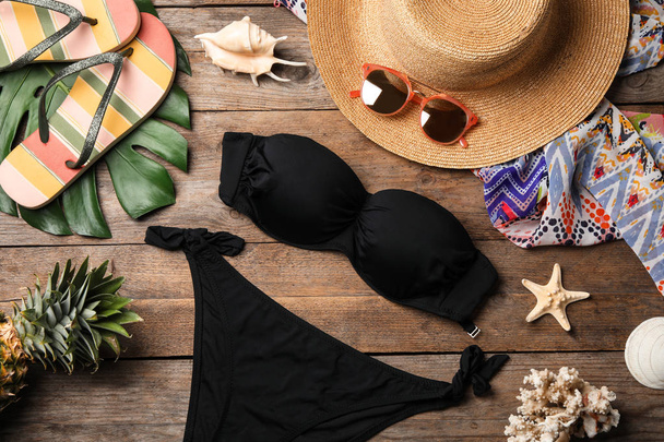 Flat lay composition with swimsuit and beach accessories on wooden background - Foto, Bild