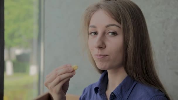Όμορφο κορίτσι κρατώντας τηγανισμένες πατάτες σε ένα φαστ φουντ εστιατόριο - Πλάνα, βίντεο