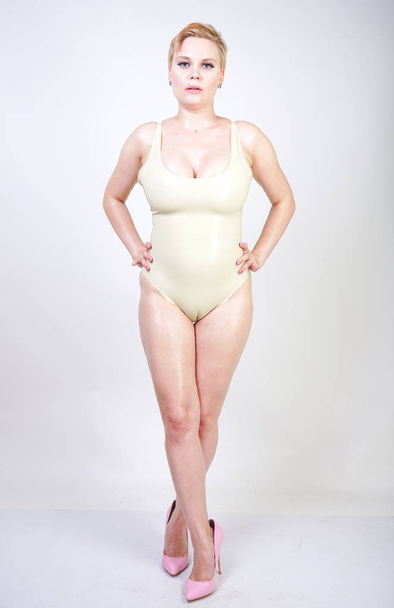 sexy hot short hair molliges Mädchen trägt Latex-Gummiunterwäsche und posiert auf weißem Studiohintergrund allein - Foto, Bild