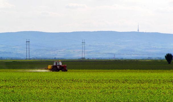 Agricultura tractor arado y pulverización en el campo - Foto, Imagen