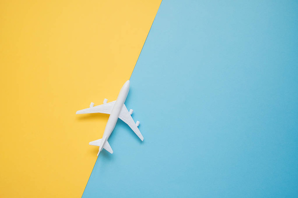 Flat lay design of travel concept with plane on blue and yellow  - 写真・画像