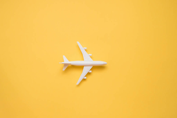 Design flat lay del concetto di viaggio con aereo su backgroun giallo
 - Foto, immagini