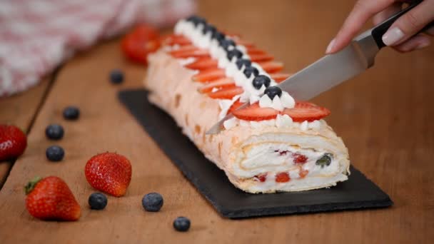 Close up, young girl is cutting meringue roulade with berries and mascarpone. - Footage, Video