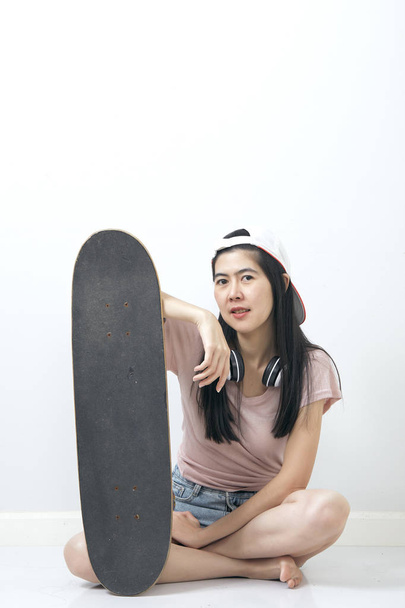 Hermosa chica asiática sosteniendo monopatín
 - Foto, imagen