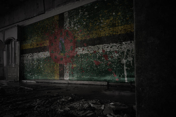 βαμμένη σημαία της Δομινίκα στον βρώμικο παλιό τοίχο σε ένα εγκαταλελειμμένο ερειπωμένο σπίτι. - Φωτογραφία, εικόνα