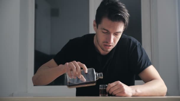 Depressiver Mann trinkt Whisky aus Glas allein in der Küche. Konzept des Alkoholismus. - Filmmaterial, Video