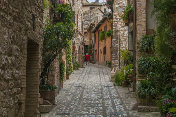 SPELLO, ITALY - MAY 11, 2019: Old woman walking for the medieval street of Spello in Umbria - Fotografie, Obrázek