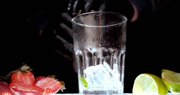 Ο μπάρμαν προετοιμάζει διάφορα ποτά (κοκτέιλ) για ένα πάρτι. Στο μπαρ στη ντίσκο ή στο σπίτι, τα κρύα ροφήματα φρούτων εμφανίζονται σε μαύρο φόντο. - Πλάνα, βίντεο