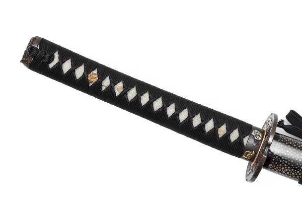 Цука: ручка японского меча, обернутая черным шелковым шнуром с золотой подкладкой на белом фоне
. - Фото, изображение