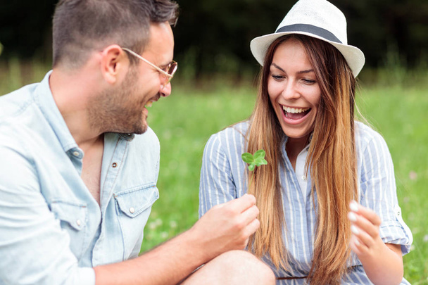 Усміхнена щаслива молода пара проводить час разом на пікніку в парку
 - Фото, зображення