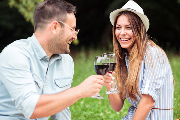 Feliz casal jovem comemorando aniversário ou aniversário com um brinde de vinho
 - Foto, Imagem