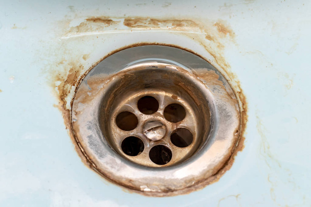 Dirty sink drain mesh, hole with limescale or lime scale and rust on it close up, dirty rusty bathroom washbowl - Photo, image