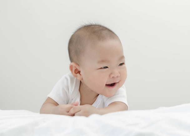 piccolo asiatico felice bambino infante rilassante e sorridente in letto
 - Foto, immagini