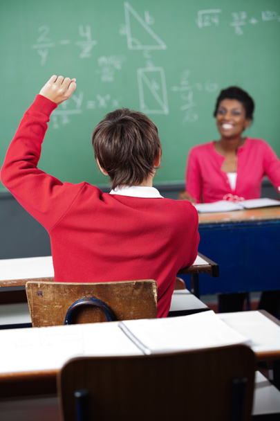 Adolescente escolar levantando la mano en el escritorio
 - Foto, imagen