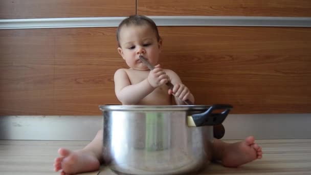 χαριτωμένο έξι μηνών μωρό αγόρι παίζει με το μαγείρεμα Pot και ξύλινη κουτάλα - Πλάνα, βίντεο